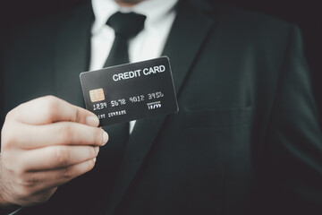 Business man with black suit and black necktie showing mockup black credit card