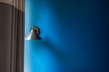 Classic lamp with dark blue tone dirty concrete background wall.