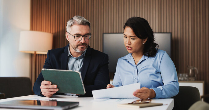 Paperwork, tablet and business people in office with discussion for finance report for budget planning. Collaboration, digital technology and manager with financial advisor for investment deal review