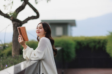 Obraz premium Woman smiling reading book enjoying quiet moment outdoors