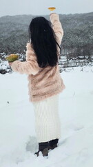 A woman holds a glass of champagne against a backdrop of snow-capped mountains