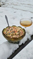 Olivier salad and a glass of champagne against a snowy backdrop