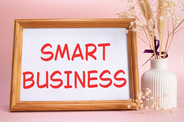 Smart business symbol. Concept words Smart business on beautiful wooden picture frame. Beautiful pink background with flower vase. Business and Smart business concept. Copy space.