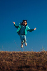 Cheerful Little Girl Jumps Outside During the Cold Season. Joyful kid enjoying childhood and movement to the fullest 
