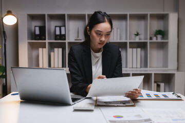 Businesswoman analyzing financial reports late at night