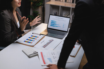 Business people discussing financial data and sales reports