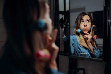 Woman with Hair Curlers Making Plans in the Mirror. Doubtful lady thinking about her looks feeling insecure
