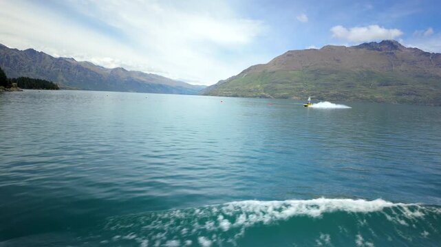 Calm lake water with mountains and boat wake