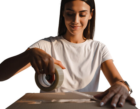 Smiling young woman in white t shirt diligently seals a cardboard box with clear packing tape, hands applying adhesive, isolated on white background