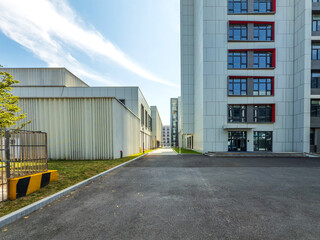 Obraz premium Modern Industrial Facility Surrounded by Contemporary Architecture and Clear Blue Sky