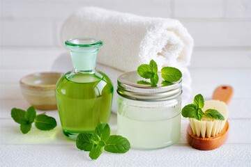 Natural skincare products with mint leaves on white background