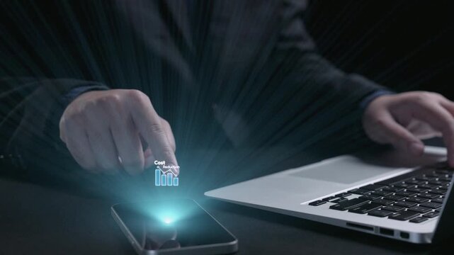 A businessman types on a laptop with digital graphics showcasing cost reduction strategies. The modern workspace reflects financial analysis through technology and innovation. Qubit