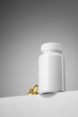 White supplement bottle with golden softgel capsules. Hero view shot.