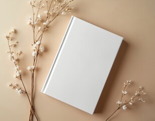 Blank white book cover mockup on beige background with delicate dry flowers. Minimalist composition for book design or branding. Natural, elegant, and clean visual for print or web projects.