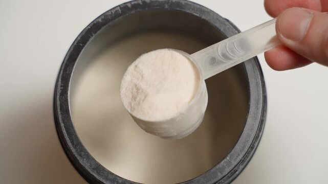 Scooping up a full scoop of powdered collagen, close-up