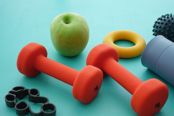 Weights, an apple, and exercise tools on a table