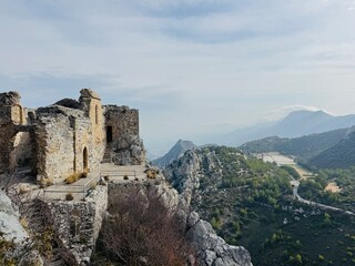 St. Hilarion Castle surrounded by the Kyrenia Mountains in soft morning mist, creating an atmospheric view of the medieval fortress rising above the landscape of northern Cyprus