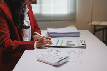 Professional woman analyzing financial data on documents