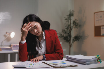Stressed businesswoman suffering headache working late at office