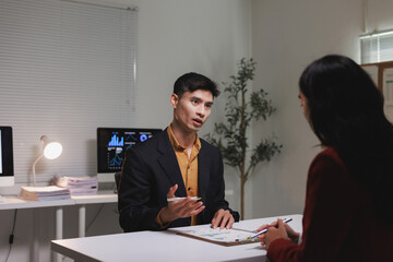 Businessman discussing data with female colleague in office