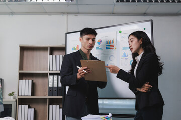 Business colleagues analyzing data on whiteboard in office