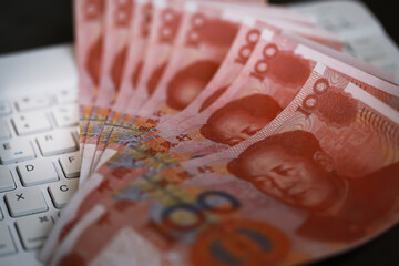 Chinese Yuan Banknotes Spread Over a Computer Keyboard Highlighting Digital Economy and Finance Trends