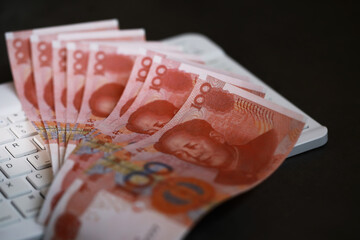 Chinese Yuan Banknotes on Keyboard Representing Online Financial Transactions and Economy Trends
