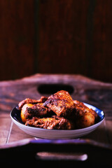 Fried chicken wings with potatoes on a rustic background. Soft focus.
