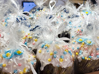 Easter kulich with white glaze and colorful sprinkles.