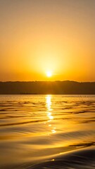 Fototapeta premium Golden sunset paints the water and sky with vibrant hues