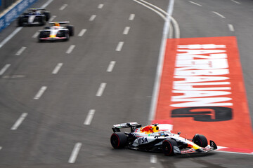 Obraz premium BAKU, AZERBAIJAN - SEPTEMBER 20, 2025: RB Formula 1 car navigates a high-speed turn over the distinctive AZERBAIJAN GP track branding during the qualifying session for the 2025 Azerbaijan Grand Prix