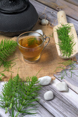 Equisetum arvense herbal tea with iron teapot and wooden scoop on rustic background