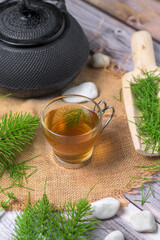 Equisetum arvense herbal tea with iron teapot and wooden scoop on rustic background