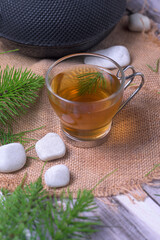 Equisetum arvense herbal tea with iron teapot and wooden scoop on rustic background