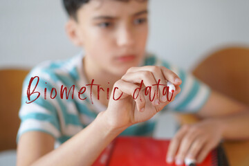 biometric data. children and use of technologies. Preteen boy writing text on the screen with a red marker