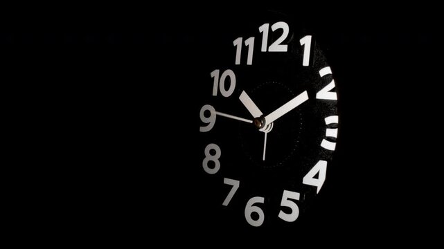 Tme lapse video of a clock time passing over a day to night on black background.