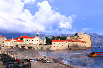Old town, fortress wall and Adriatic sea, Budva, Montenegro. Beautiful scene with medieval houses and seascape. Topic of summer vacation, travel, cruises, tour