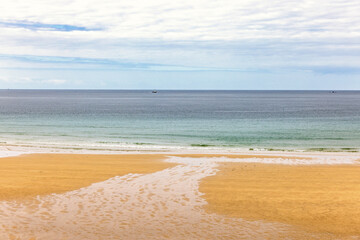 Running water on a sand beach with a seascape view