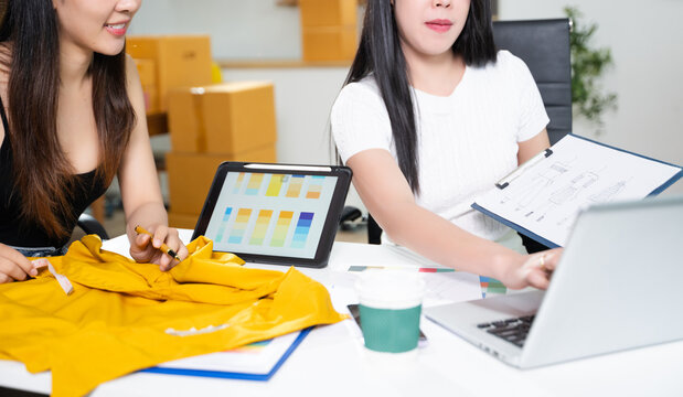 Creative fashion designers collaborating with fabric and color palette using digital tablet. Modern fashion studio, textile planning and startup business concept - Powered by Adobe