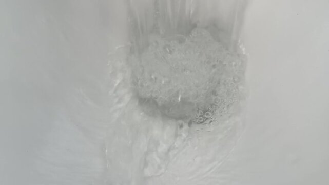 Close Up View of Water Swirling and Flushing in White Toilet Bowl