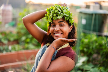 Young woman smiling with fresh cilantro during organic farming