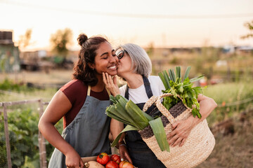Mother and daughter celebrating fresh garden harvest with affection