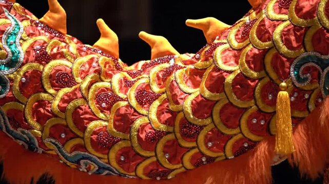 A colorful dragon performing during a traditional Chinese New Year celebration at night with a dark background