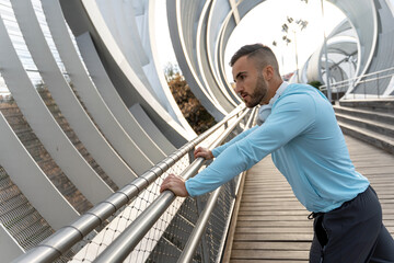 Focused athlete stretching in a modern urban setting during the golden hour