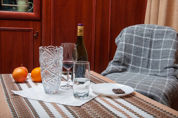 Cozy evening setting with wine, fruit, and chocolate on a decorated table