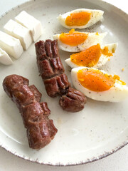 sausage and sliced soft boiled egg on plate