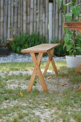 Fototapeta premium Small Wooden Folding Stool on Pebbled Ground
