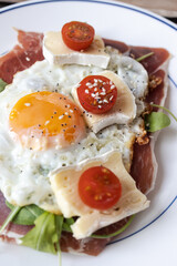 Fried egg, prosciutto, camembert and cherry tomato breakfast plate
