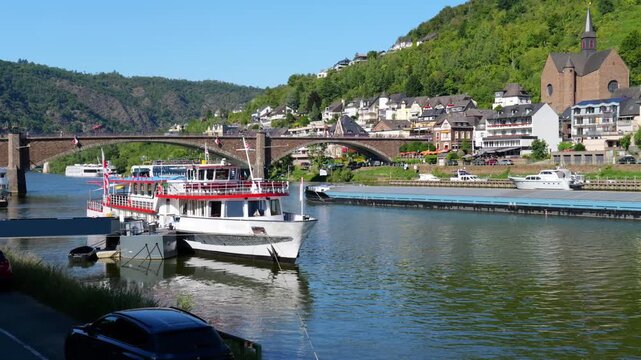 Cochem, Germany- view of the Moselle with bridge and excursion boats , summer atmosphere and cityscape