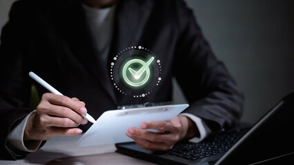 Business person holding clipboard with virtual check mark icon for quality assurance and document approval.